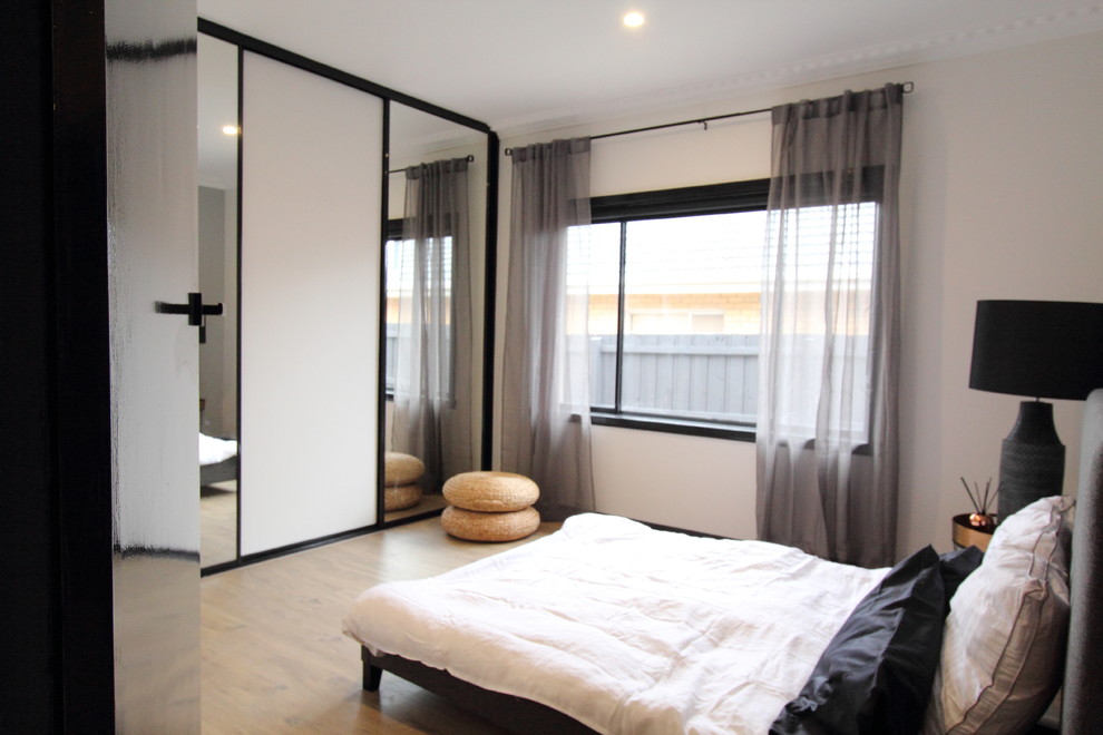 Mittelgroßes Industrial Hauptschlafzimmer mit grauer Wandfarbe und Laminat in Melbourne