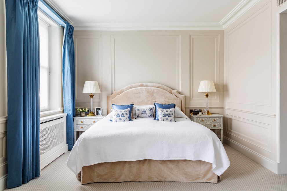 На фото: хозяйская спальня в стиле неоклассика (современная классика) с бежевыми стенами, ковровым покрытием, бежевым полом и синими шторами с