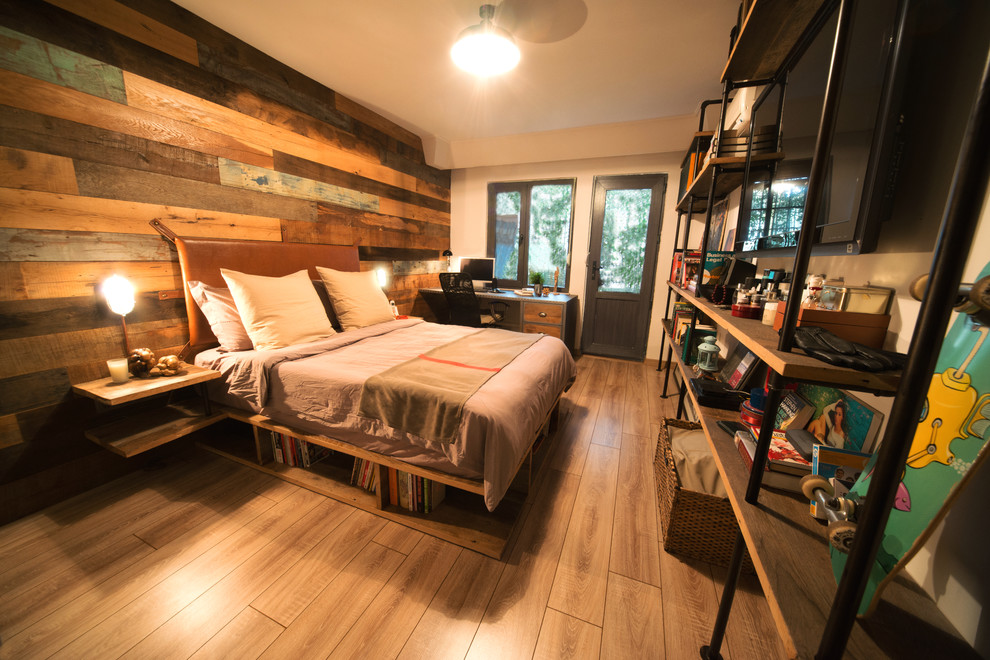 Ejemplo de dormitorio principal industrial de tamaño medio con paredes blancas y suelo de madera clara