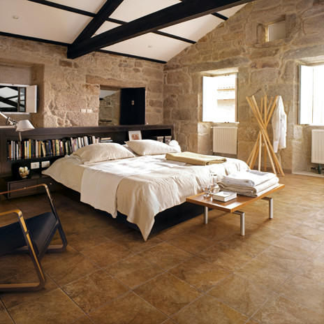 Ispirazione per una camera matrimoniale country con pareti beige e pavimento in gres porcellanato