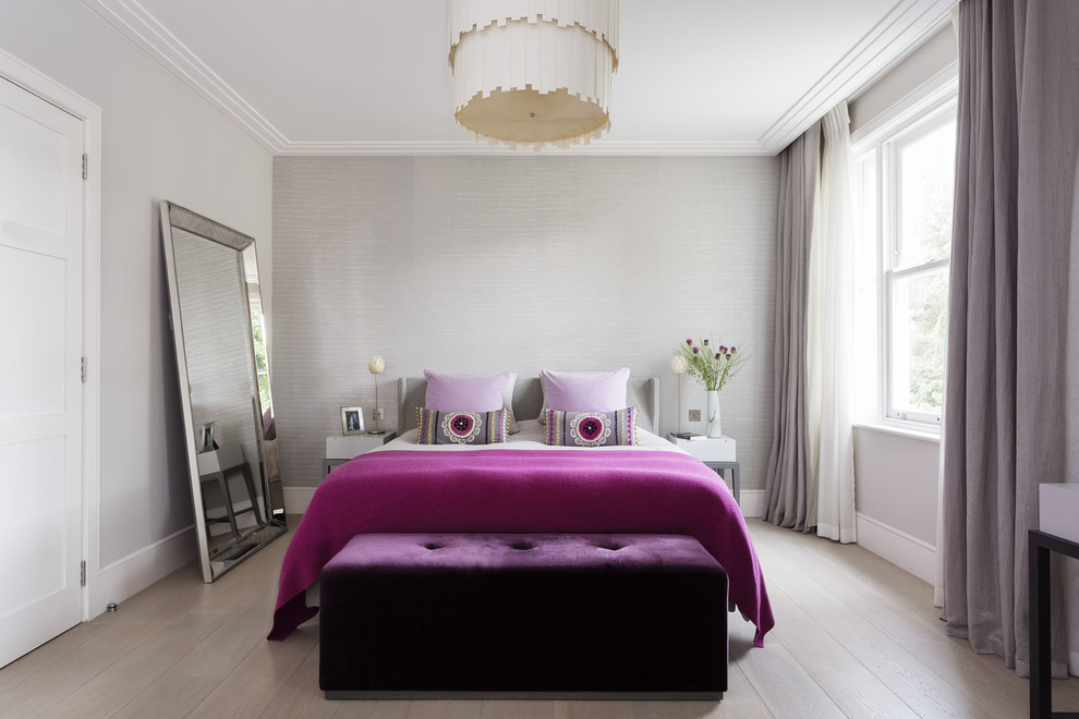 Modelo de dormitorio contemporáneo sin chimenea con paredes grises y suelo de madera clara