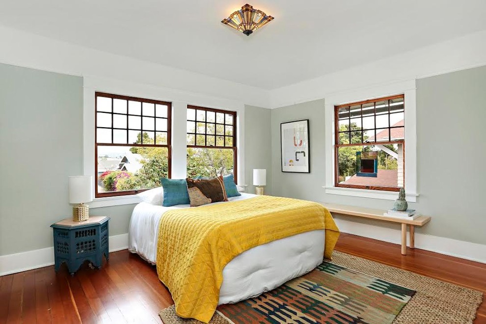 Aménagement d'une chambre craftsman de taille moyenne avec un sol en bois brun, un sol marron et un mur gris.