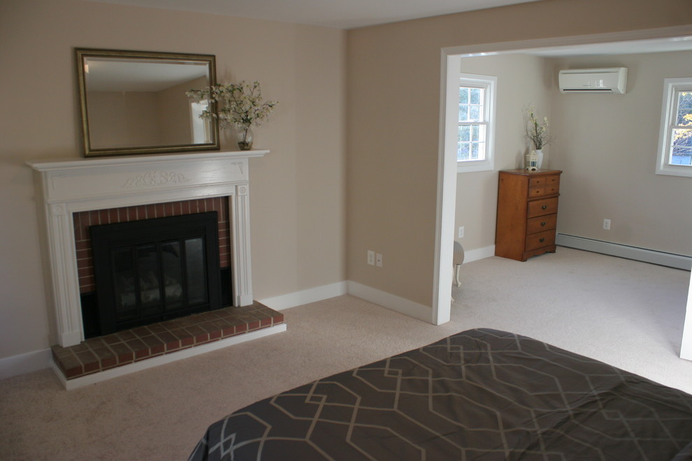 Foto de dormitorio principal moderno de tamaño medio con paredes beige, moqueta, todas las chimeneas y marco de chimenea de ladrillo