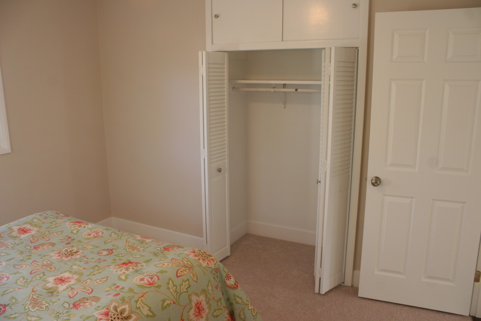 This is an example of a medium sized modern guest bedroom in Baltimore with beige walls and carpet.