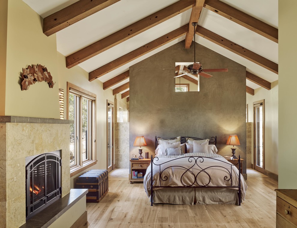 Bedroom - rustic light wood floor and beige floor bedroom idea in San Francisco with beige walls and a standard fireplace