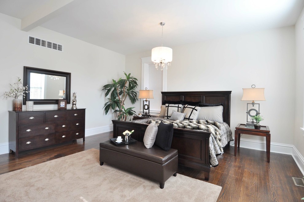 Ejemplo de dormitorio principal clásico grande sin chimenea con suelo de madera oscura, paredes blancas y suelo marrón