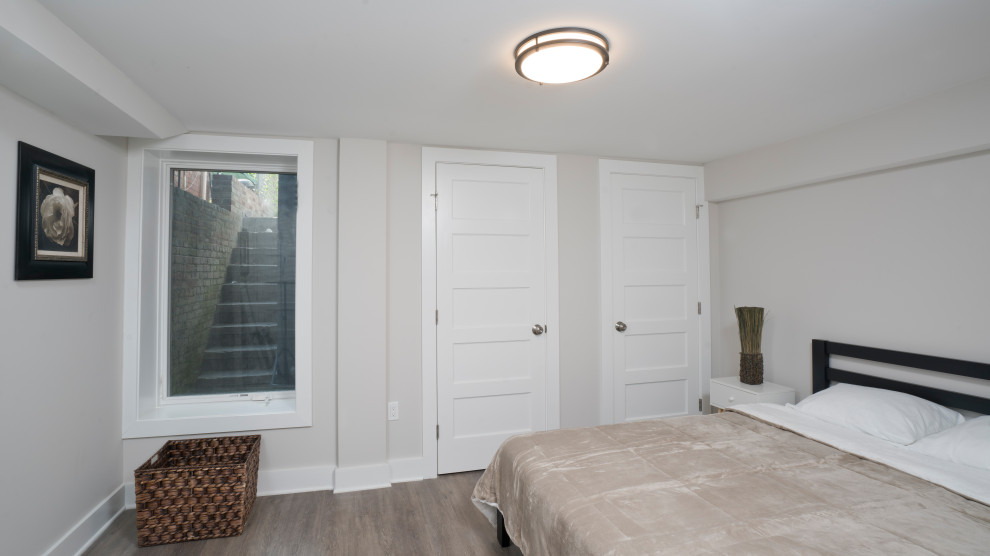 На фото: спальня в стиле модернизм с белыми стенами, полом из винила и серым полом с