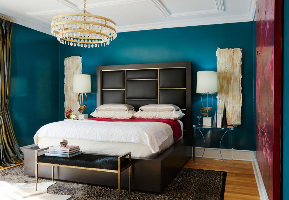 Modelo de dormitorio principal clásico renovado con paredes azules y suelo de madera en tonos medios