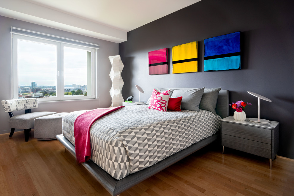 Cette image montre une chambre parentale grise et rose design de taille moyenne avec un mur noir et un sol en bois brun.