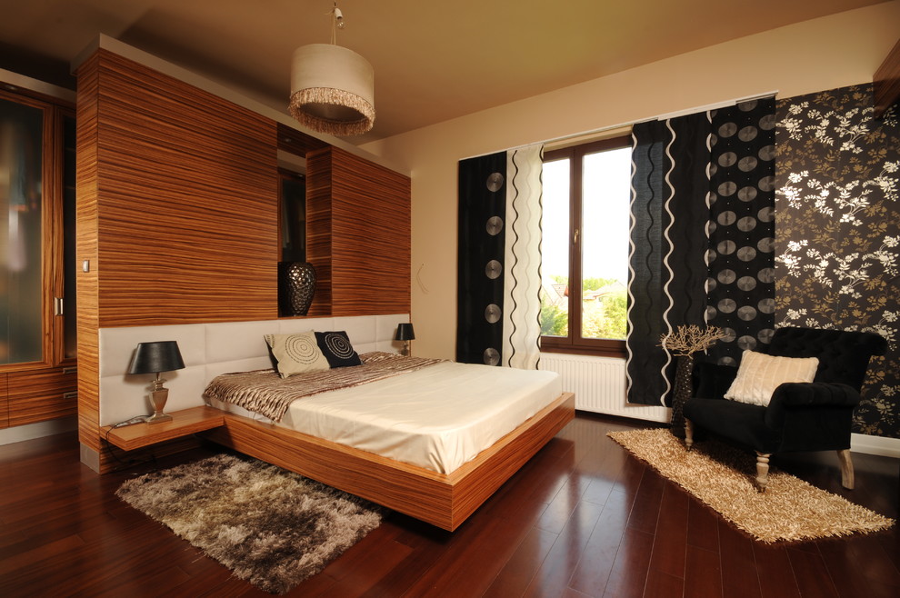 Modern inredning av ett sovrum, med beige väggar och mörkt trägolv