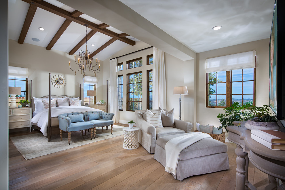 Large tuscan master medium tone wood floor bedroom photo in Orange County with beige walls