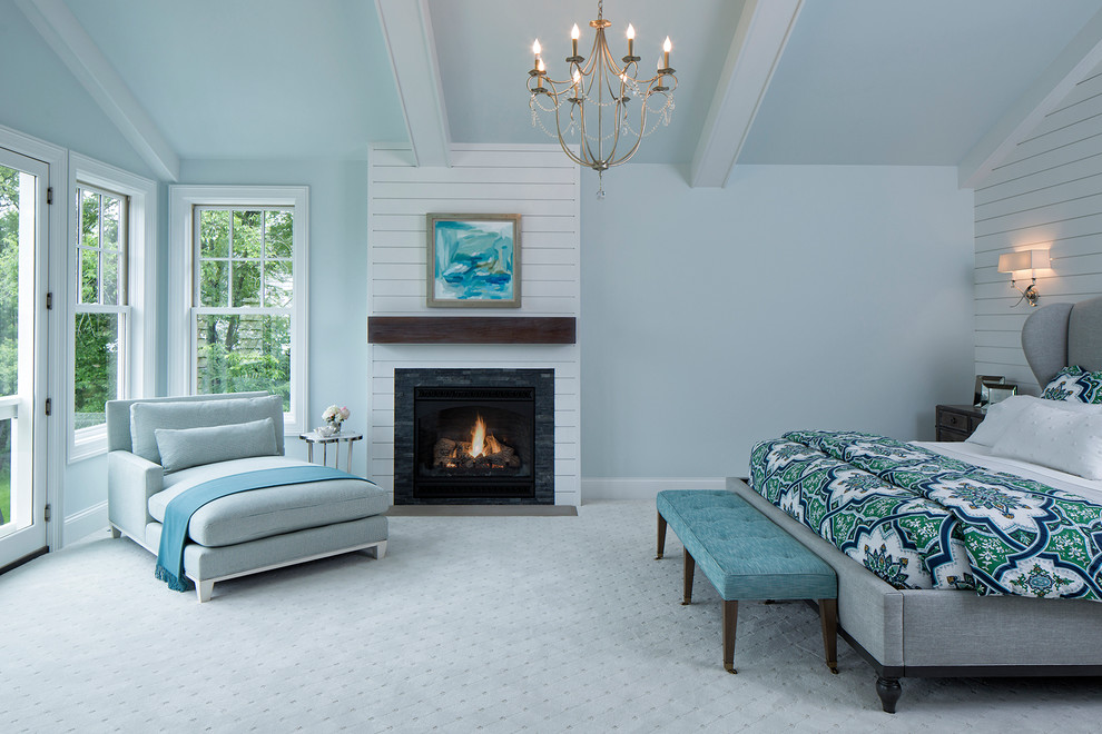 Maritimes Hauptschlafzimmer mit blauer Wandfarbe, Teppichboden, Kamin und Kaminumrandung aus Holz in Minneapolis