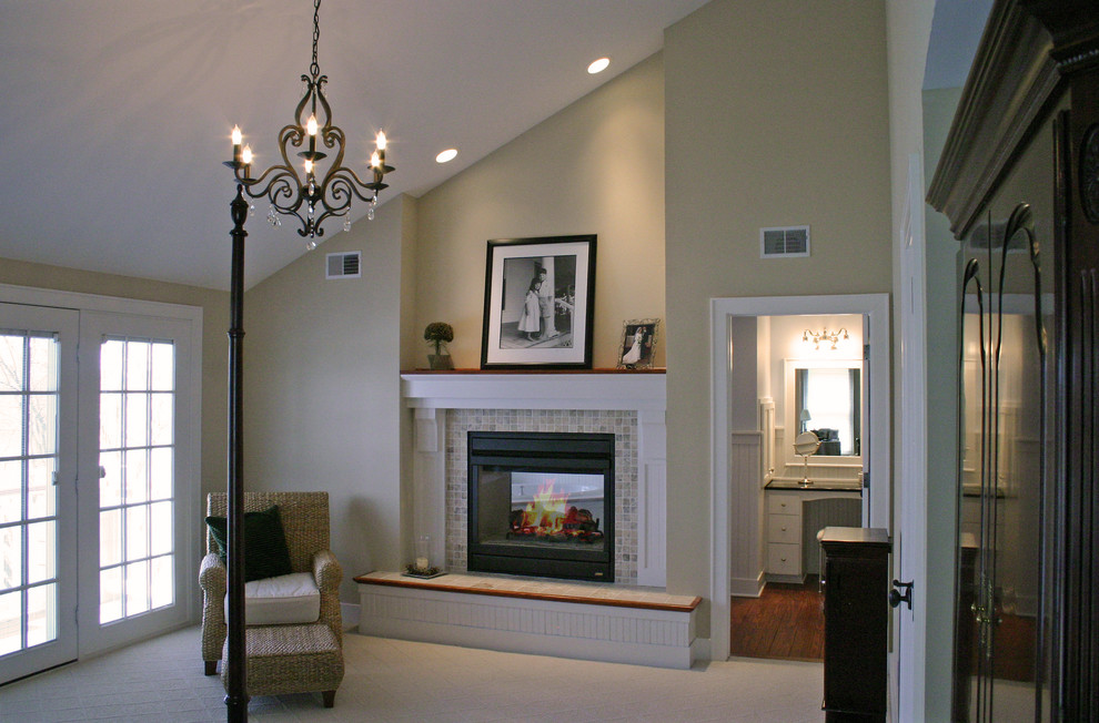 Aménagement d'une chambre classique de taille moyenne avec un mur beige, une cheminée double-face et un manteau de cheminée en carrelage.