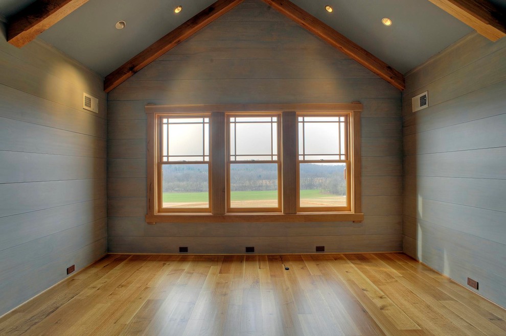 Diseño de dormitorio principal de estilo americano con paredes azules y suelo de madera en tonos medios