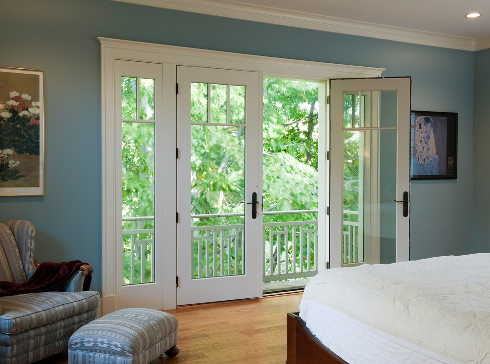 Foto di una camera degli ospiti stile americano con pareti blu e parquet chiaro