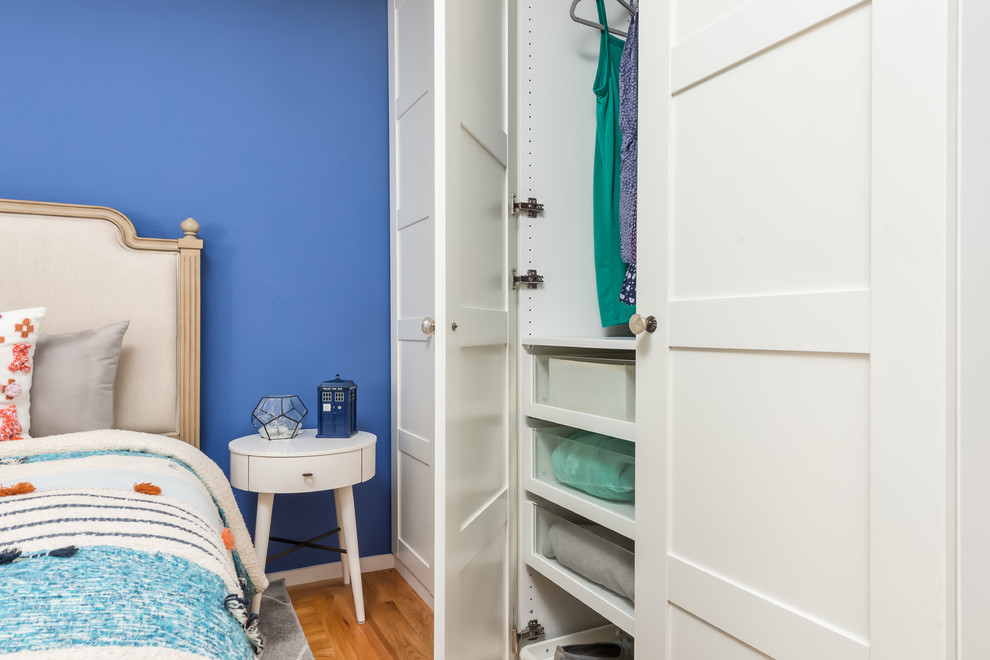 Kleines Eklektisches Gästezimmer ohne Kamin mit blauer Wandfarbe, hellem Holzboden und orangem Boden in San Francisco