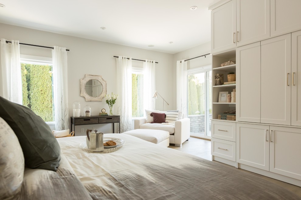 Diseño de dormitorio principal clásico renovado grande con paredes blancas, suelo de madera clara y suelo beige