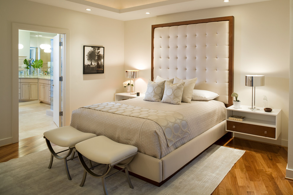 Foto di una camera da letto contemporanea con pareti beige e pavimento in legno massello medio
