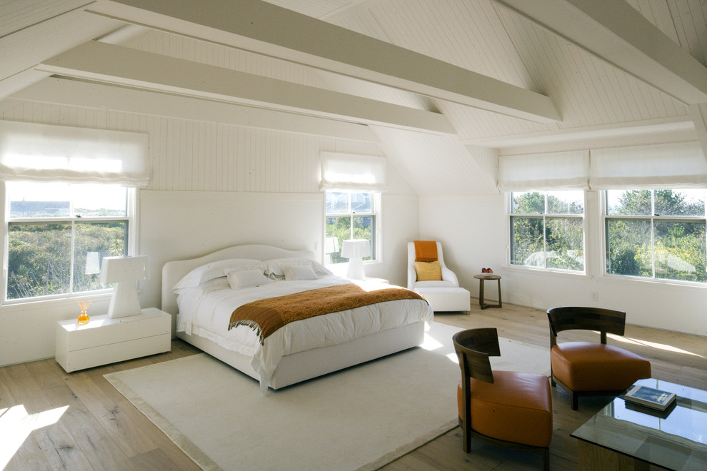 Idée de décoration pour une chambre chalet avec un mur blanc et un sol en bois brun.