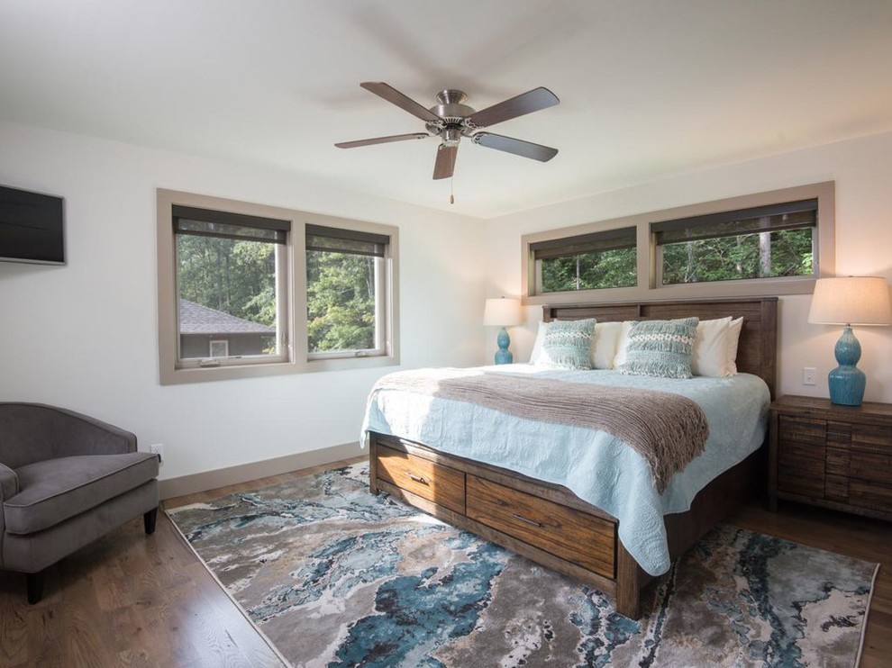 This is an example of a medium sized modern guest bedroom in Other with beige walls and light hardwood flooring.