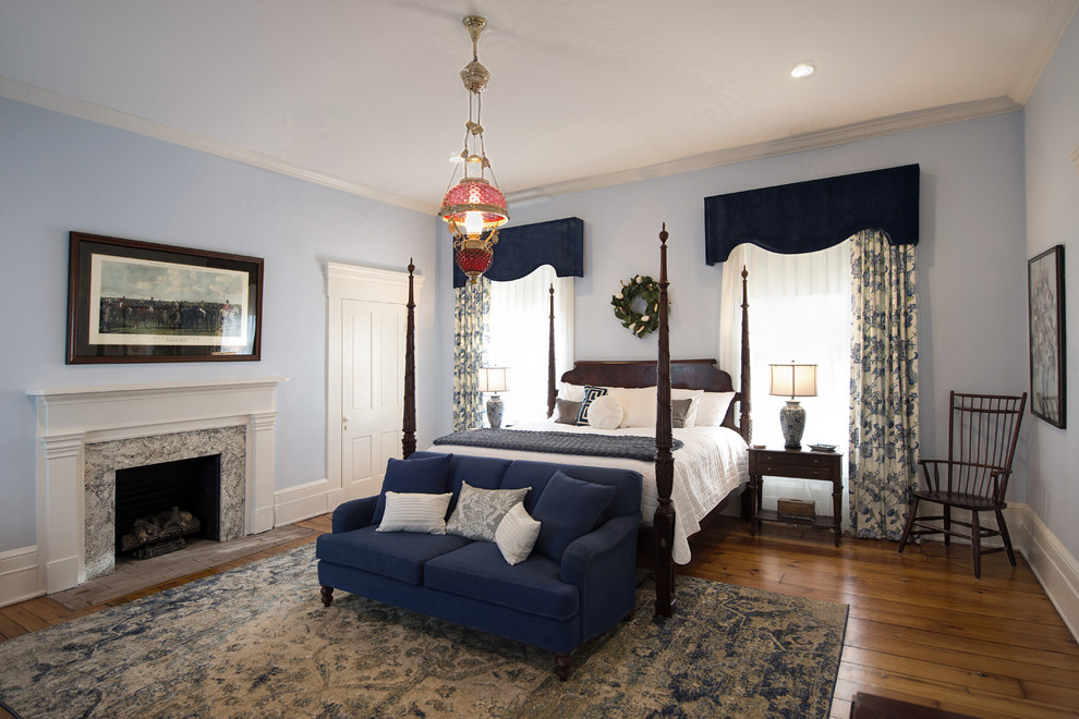 Пример оригинального дизайна: большая хозяйская спальня в классическом стиле с синими стенами, паркетным полом среднего тона, стандартным камином, фасадом камина из штукатурки и коричневым полом