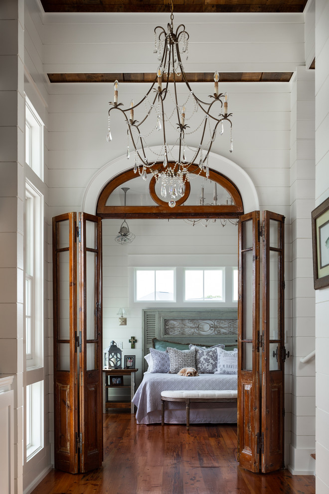 Foto di una camera da letto stile marino con pareti bianche, parquet scuro e pavimento marrone