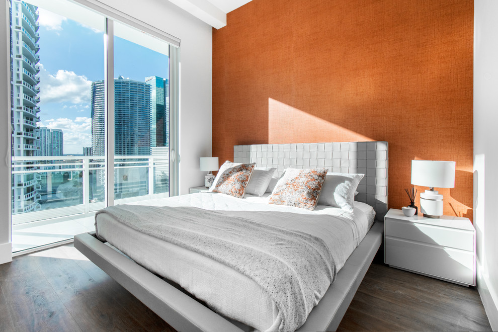 Immagine di una camera da letto contemporanea con pareti arancioni, parquet scuro e pavimento marrone