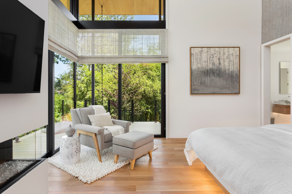 Geräumiges Modernes Hauptschlafzimmer mit weißer Wandfarbe, hellem Holzboden, Gaskamin und beigem Boden in Portland