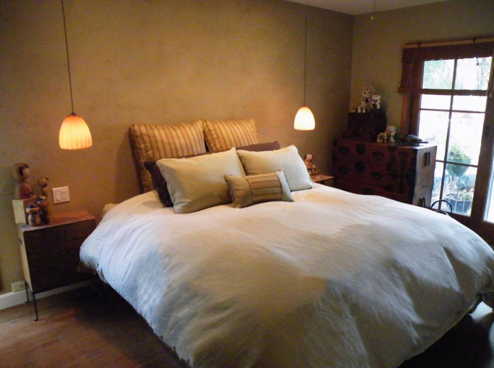 Ejemplo de dormitorio principal asiático pequeño con paredes amarillas y suelo de bambú