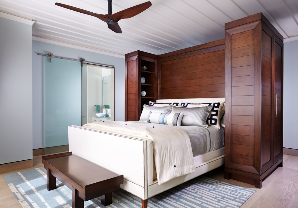 Modelo de dormitorio principal contemporáneo de tamaño medio sin chimenea con paredes azules, suelo de madera clara y suelo beige