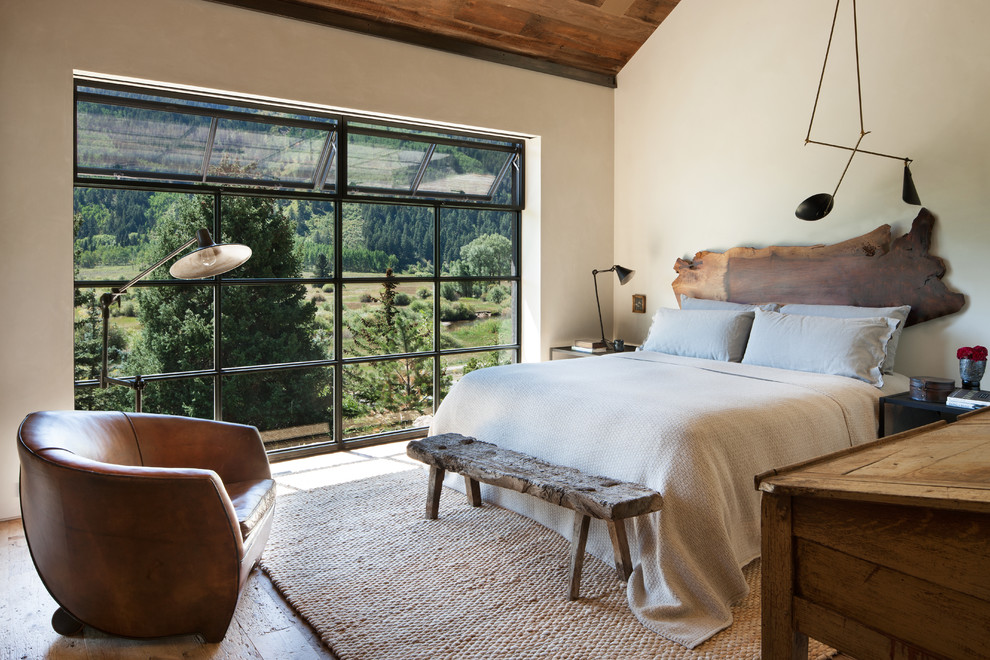 Modelo de dormitorio principal rural sin chimenea con paredes blancas y suelo de madera en tonos medios