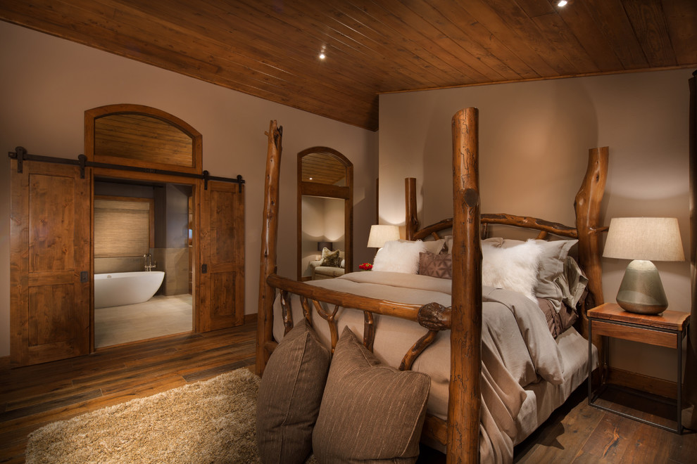 На фото: спальня в стиле рустика с бежевыми стенами и паркетным полом среднего тона