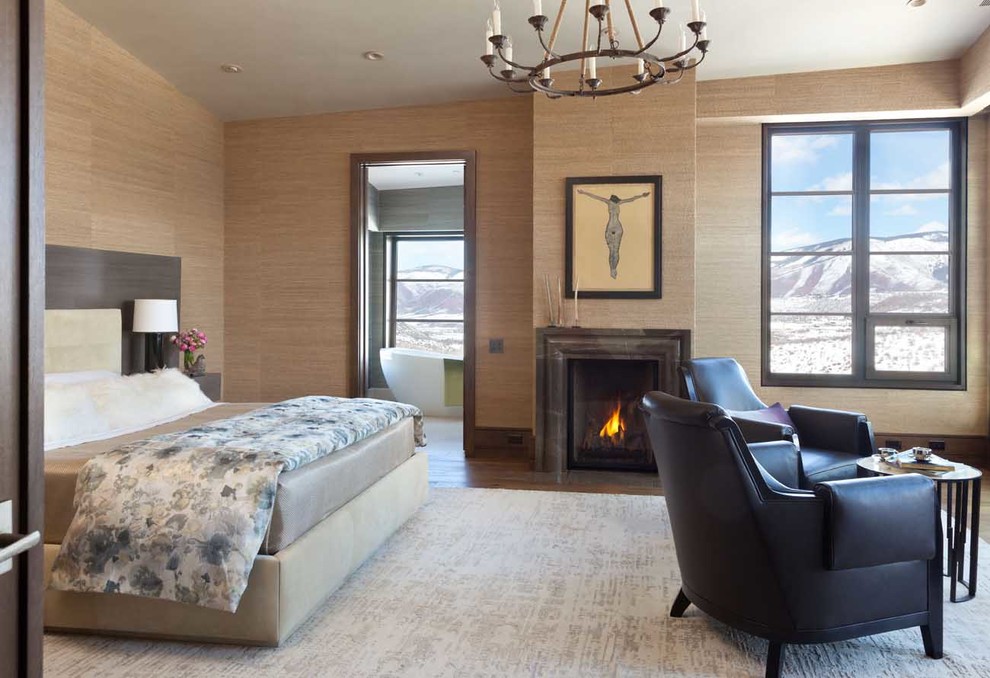 Bedroom - large rustic master medium tone wood floor bedroom idea in Denver with beige walls, a standard fireplace and a stone fireplace