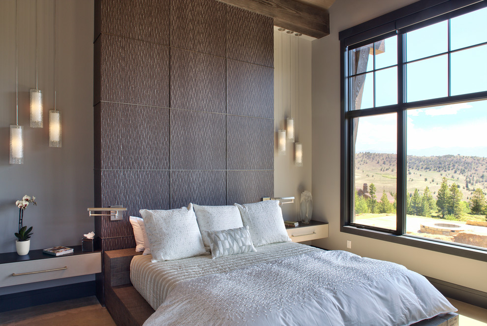 Esempio di una camera da letto design con pareti grigie, pavimento in legno massello medio e pavimento marrone