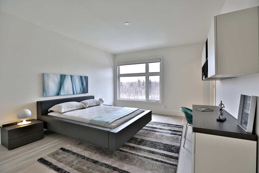 Diseño de habitación de invitados minimalista grande con paredes blancas y suelo de madera clara