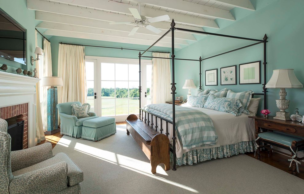 Diseño de dormitorio principal campestre con paredes azules, suelo de madera en tonos medios, todas las chimeneas y marco de chimenea de ladrillo