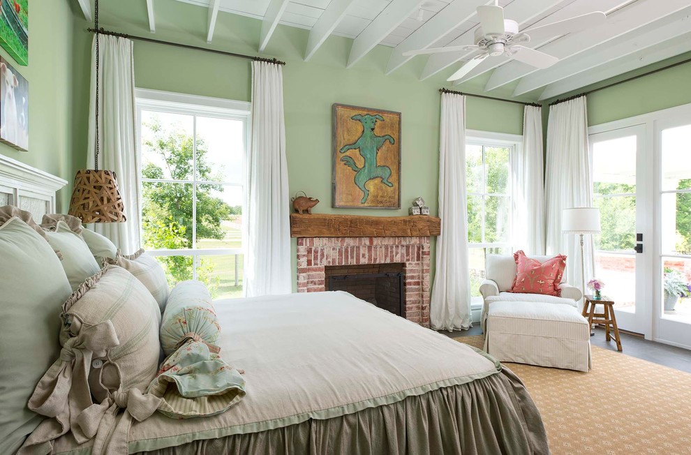 Foto på ett lantligt sovrum, med gröna väggar, en standard öppen spis och en spiselkrans i tegelsten