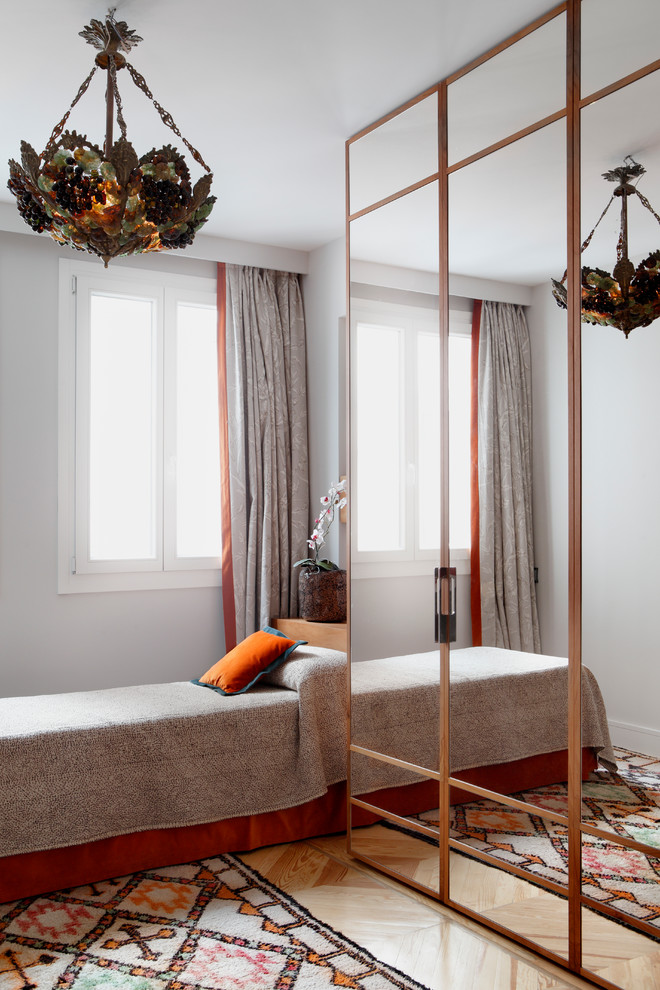 Mittelgroßes Mediterranes Gästezimmer ohne Kamin mit grauer Wandfarbe und braunem Holzboden in Madrid