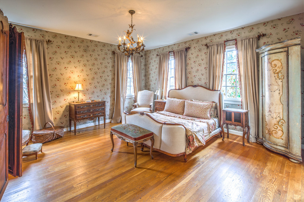 Ejemplo de dormitorio principal tradicional grande sin chimenea con suelo de madera en tonos medios y paredes multicolor