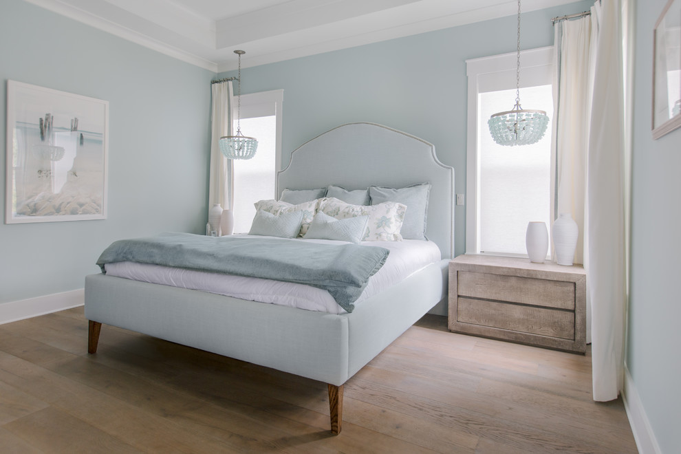 ジャクソンビルにある広いビーチスタイルのおしゃれな主寝室 (青い壁、セラミックタイルの床、茶色い床)