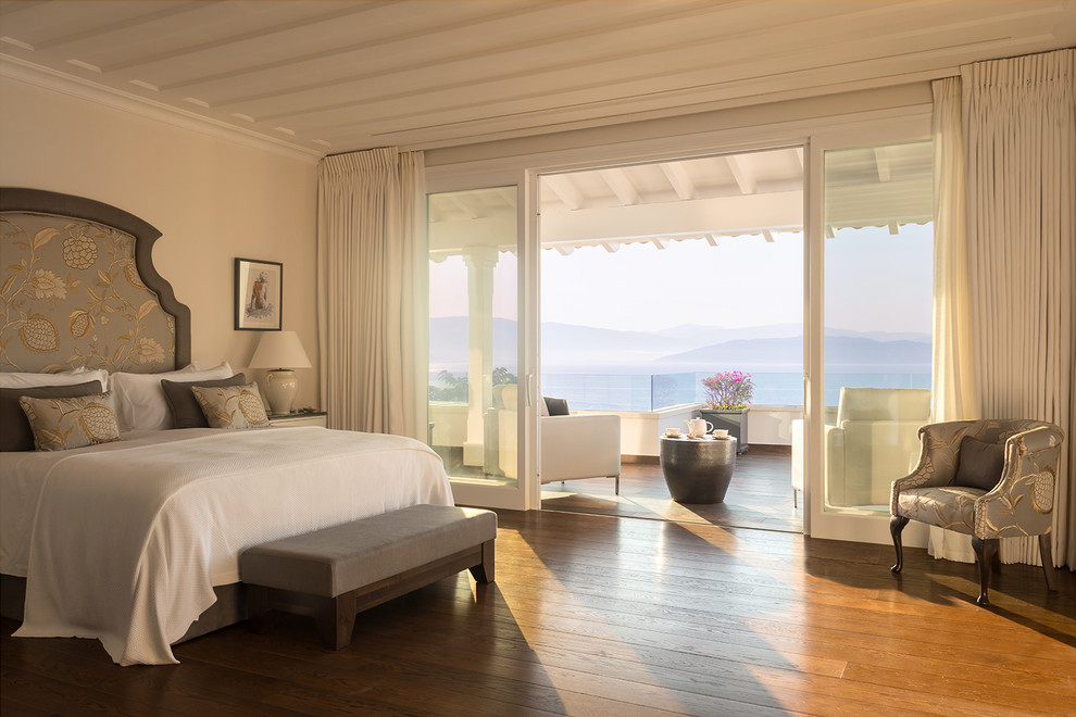 Large beach style master dark wood floor and brown floor bedroom photo with beige walls
