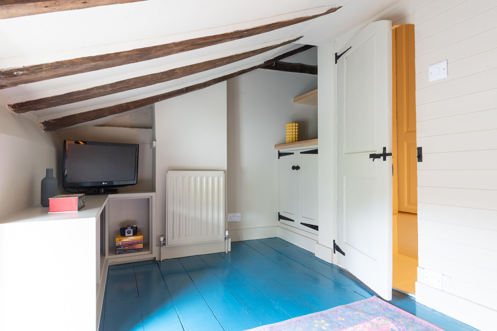 他の地域にある小さなエクレクティックスタイルのおしゃれな客用寝室 (ベージュの壁、塗装フローリング、暖炉なし、青い床) のインテリア