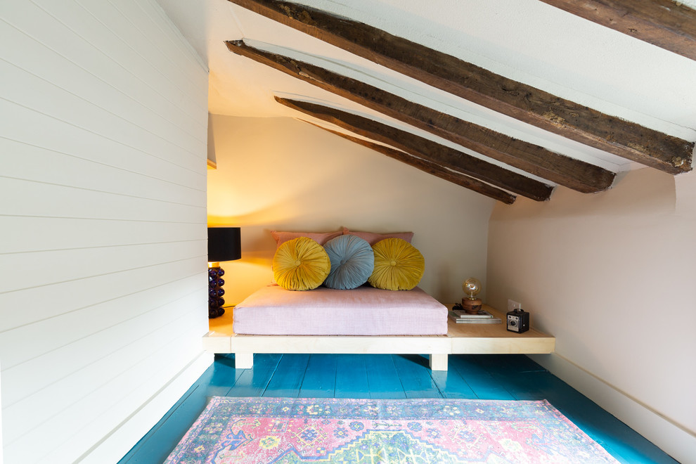 Cette image montre une petite chambre d'amis bohème avec un mur beige, parquet peint, aucune cheminée et un sol bleu.