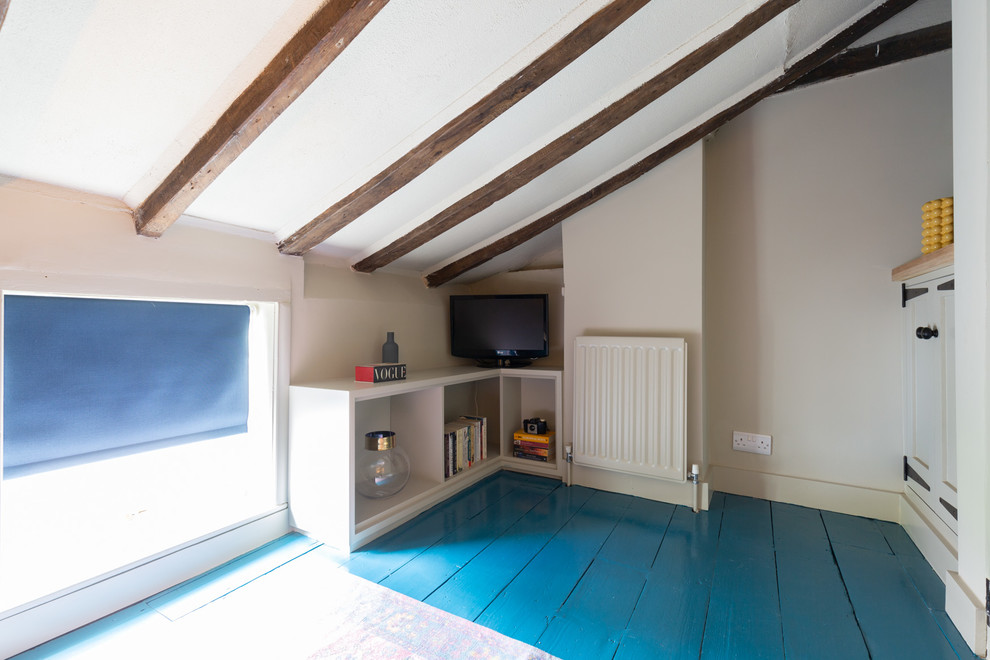 Immagine di una piccola camera degli ospiti bohémian con pareti beige, pavimento in legno verniciato, nessun camino e pavimento blu