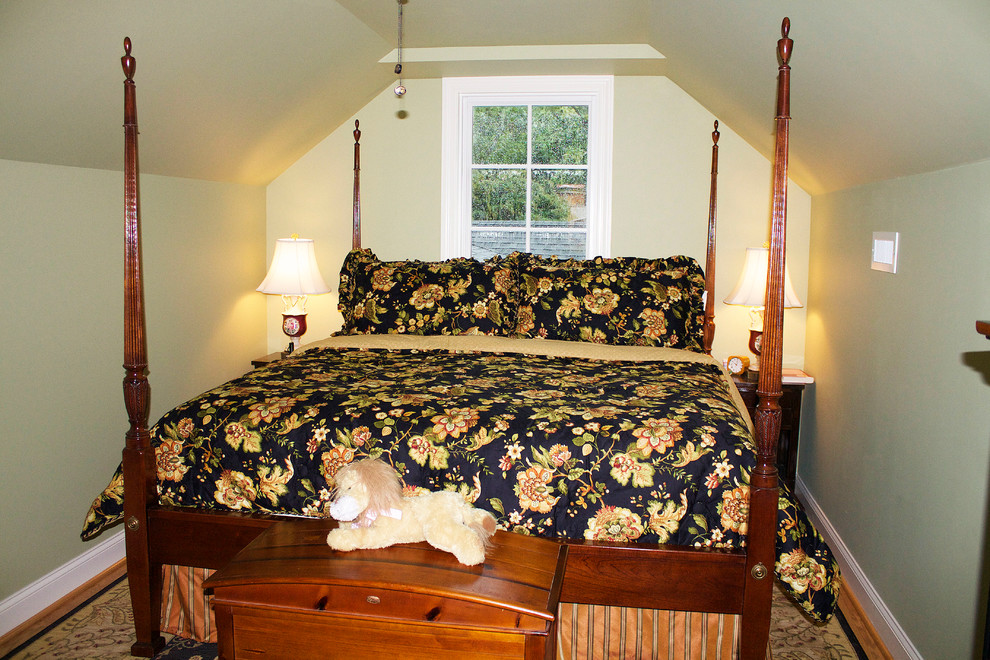 Modelo de habitación de invitados clásica de tamaño medio sin chimenea con paredes verdes y suelo de madera en tonos medios