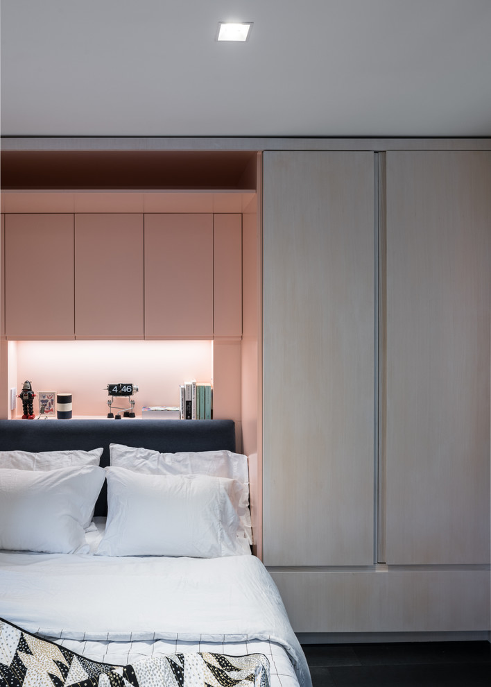Foto de dormitorio principal minimalista pequeño con paredes rosas y suelo de madera oscura