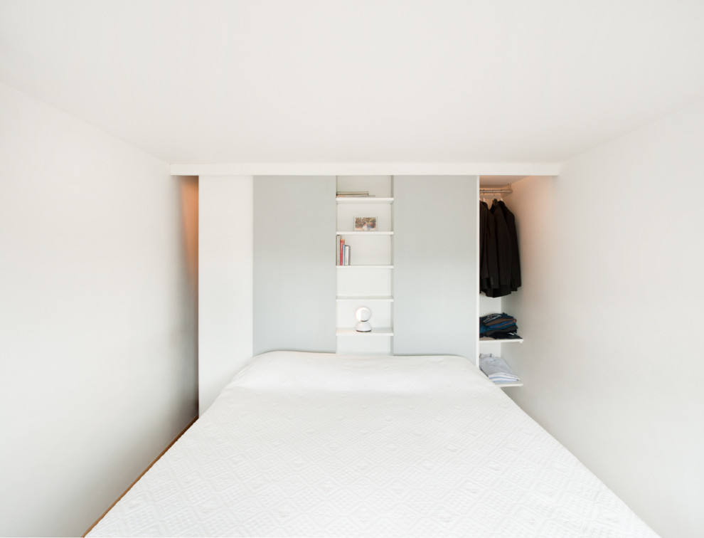 Modelo de dormitorio principal actual pequeño con paredes blancas, suelo de madera en tonos medios y suelo beige