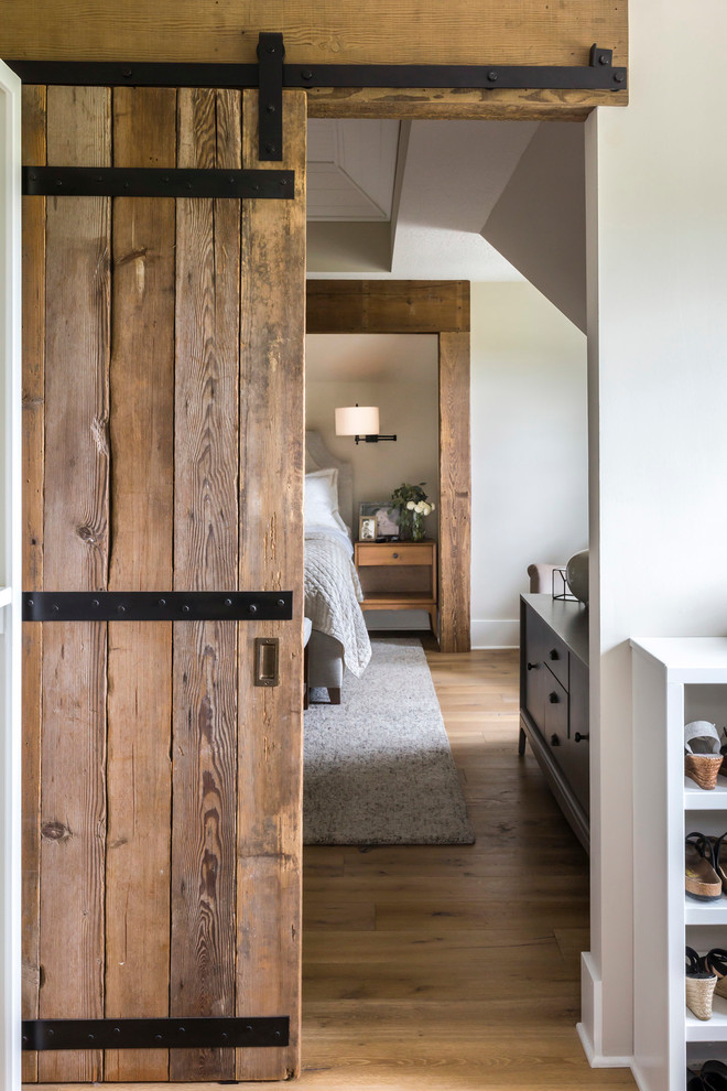 Imagen de dormitorio principal clásico renovado grande con paredes grises y suelo de madera clara