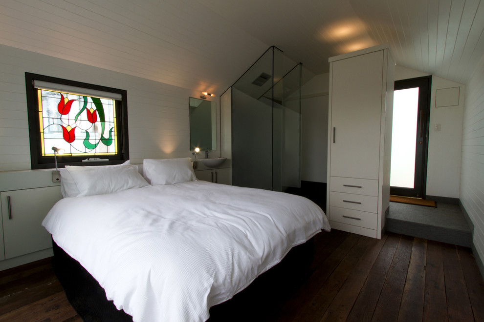 Modelo de habitación de invitados costera pequeña con paredes blancas y suelo de madera oscura