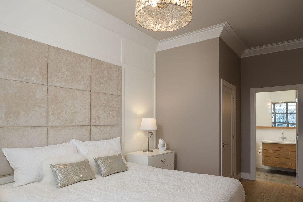 Modelo de dormitorio principal tradicional renovado de tamaño medio con paredes multicolor, suelo de madera clara y suelo marrón